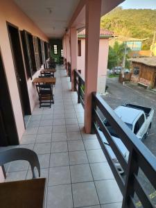 a balcony of a building with tables and chairs at Pousada Terranova in Garopaba