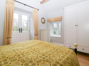 a bedroom with a bed and two windows at Velindra Farm Cottage in Hereford