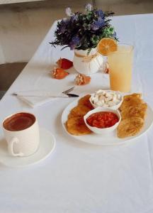 une table avec une assiette de nourriture et une tasse de café dans l'établissement El legado de las olas, à Carthagène des Indes