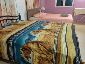 two beds in a room with a blanket on them at Henz and Sia Tourist residence in Port Mathurin