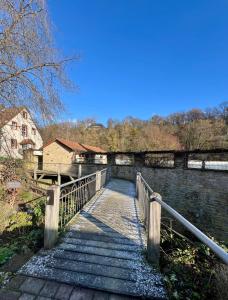 a wooden bridge over a river with a building at Fewo Geib in Meisenheim