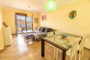 a living room with a table and a couch at RentitSpain - Almuñecar - Vistas Increíbles al mar en Apartamentos Lambda in Almuñécar