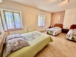 ein Schlafzimmer mit zwei Betten und zwei Fenstern in der Unterkunft La Coccinelle- Gîte familial, Spa & Sauna in Lafrançaise + 31 Fotos