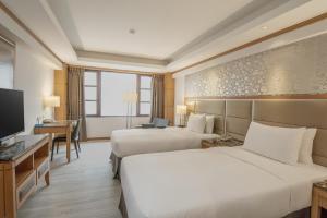 a hotel room with two beds and a television at Hotel Dion in Taichung
