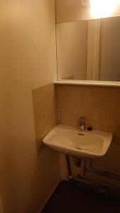 a bathroom with a white sink and a mirror at Cozy economy room for 2 persons at the shopping area in Rovaniemi