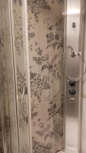 a shower in a bathroom with floral wallpaper at Cozy economy room for 2 persons at the shopping area in Rovaniemi