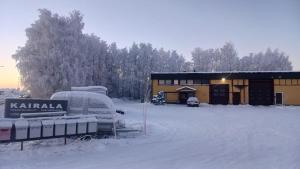 a building covered in snow with a sign in front at Cozy economy room for 2 persons at the shopping area in Rovaniemi