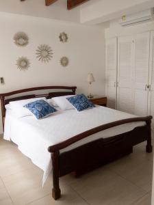 une chambre avec un grand lit blanc avec des oreillers bleus dans l'établissement Apartamento en el Centro de San Andrés Islas con vista al mar- Edificio Bay Point 703, à San Andrés