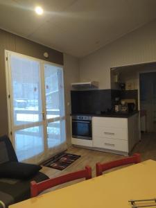 una cucina con un tavolo e una stufa forno superiore di Camping Le Coulédous ad Aulus-les-Bains