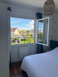 a bedroom with a bed and a large window at 2-room apartment near Marais and CV in Bourges