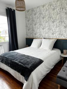 a bedroom with a large bed with a black blanket at 2-room apartment near Marais and CV in Bourges +10 photos