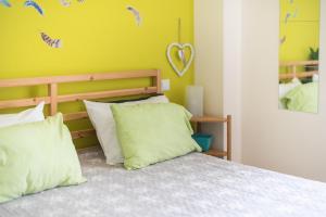 a bedroom with a bed and a yellow wall at Sweet home in Koukaki in Athens +34 photos