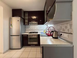 a kitchen with a stainless steel refrigerator and cabinets at Veronika Apartments in Berehove +8 photos