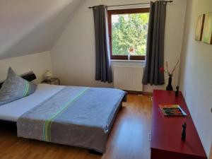 a bedroom with a bed and a table and a window at Ferienwohnung Anna in Schwarz