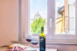 比萨Eulalia's Attic - Affitti Brevi Italia的桌上有一瓶酒和两个酒杯