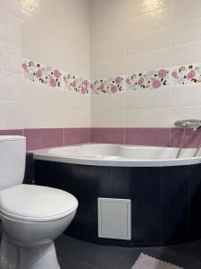 a bathroom with a toilet and a bath tub at Veronika Apartments in Berehove