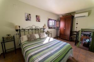 a bedroom with a bed with a striped comforter at Casa El Olivo, Landhaus Mit Bergblick in Dúrcal
