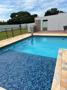Una gran piscina con azulejos azules. en Pousada Vale Canastra, en São João Batista do Glória