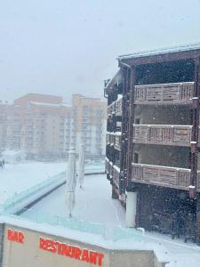 Un homme debout dans la neige à côté d'un bâtiment dans l'établissement Osciere Ski in - Out, à Val Thorens 1 autre photo