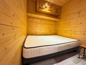 Cette chambre comprend un lit dans une cabane en bois. dans l'établissement Osciere Ski in - Out, à Val Thorens