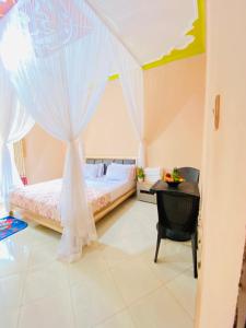 a bedroom with a bed and a window with a table at Jseason Faith-based retreat resort in Kagolomolo