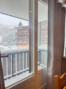 d'une fenêtre avec vue sur un balcon enneigé. dans l'établissement Osciere Ski in - Out, à Val Thorens