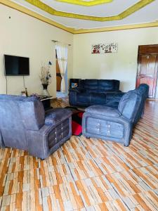 a living room with two couches and a television at Jseason Faith-based retreat resort in Kagolomolo +7 photos