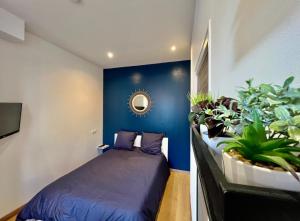 1 dormitorio con paredes azules y 1 cama con plantas en Cocon Saint-Arnould, en Saint-Omer