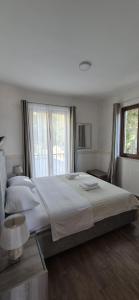 ein Schlafzimmer mit großem Bett und Fenster in der Unterkunft Bocche di Cattaro Apartments in Kotor + 150 Fotos