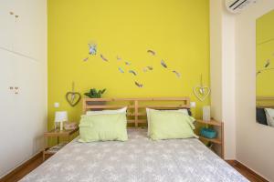 a bedroom with a bed and a yellow wall at Sweet home in Koukaki in Athens