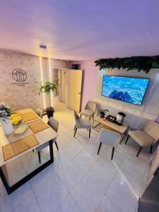 a living room with tables and chairs and a tv at Casa La Morada in Medellín