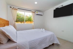 a bedroom with a white bed and a window at Hotel Arena Beach Cartagena in Cartagena de Indias