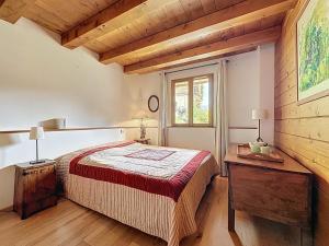 a bedroom with a bed and a table and a window at Chalet Face aux Etoiles in Molines-en-Queyras