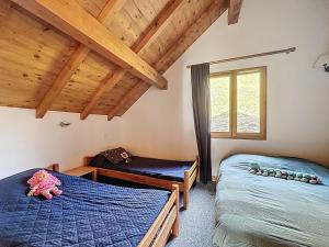 deux lits dans une chambre avec plafonds en bois dans l'établissement Chalet Face aux Etoiles, à Molines-en-Queyras