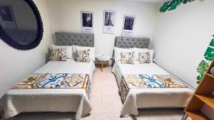 two beds in a room with a mirror at Casa La Morada in Medellín +19 photos