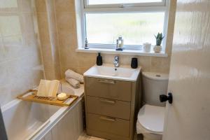 a bathroom with a sink and a toilet and a window at Lakeside Nook Garden Parking 4 people in Birmingham +56 photos