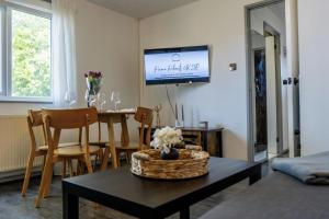a living room with a table and a tv on the wall at Lakeside Nook Garden Parking 4 people in Birmingham