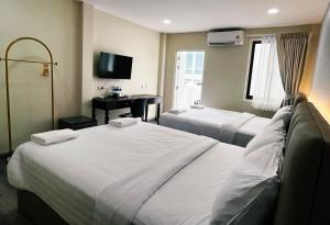 um quarto de hotel com duas camas e uma escrivaninha em Excel Hotel Bangkok former Sri Krungthep Hotel em Banguecoque mais 87 fotografias