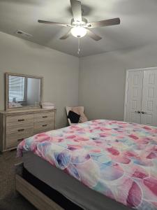 米德兰Spacious Home Perfect for Families& Business Trips的一间卧室，里面有一张床和一个吊扇