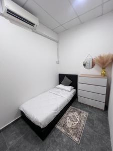 a small bedroom with a bed and a dresser at Davenah Motel Kota Marudu in Kampong Sorosob