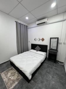 a bedroom with a large white bed and a mirror at Davenah Motel Kota Marudu in Kampong Sorosob
