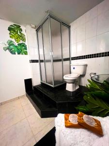 a bathroom with a toilet and a glass shower at Casa La Morada in Medellín +16 photos