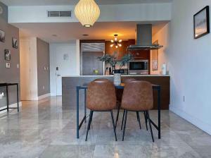 cocina con mesa, 2 sillas y barra en ICON Brickell 36th Floor View by Palermo Home Miami, en Miami