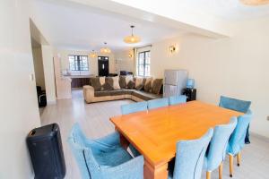 a dining room with a wooden table and blue chairs at Stixx By The Mountain in Nanyuki