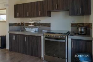 een keuken met houten kasten, een fornuis en een wastafel bij Ecohouse Pachacamac in Pachacamac +17 foto's