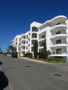 a large white apartment building on a street at Apartment with terrace Albufeira Olhos de Água in Albufeira