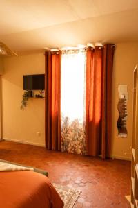 a bedroom with a bed and a large window at Cosy Cloître, apt authentique centre Arles in Arles