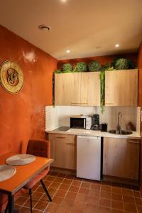 a kitchen with wooden cabinets and a white refrigerator at Cosy Cloître, apt authentique centre Arles in Arles