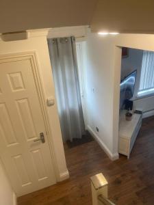 un pasillo con una puerta blanca y una habitación en Cassandra Homes, en Nevendon 13 fotos más