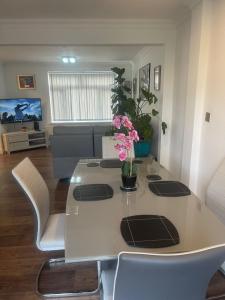 Una sala de estar con una mesa con flores. en Cassandra Homes, en Nevendon